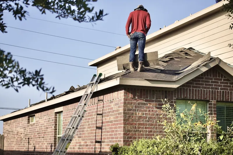 Professional roofer working on a residential roof in Goochville